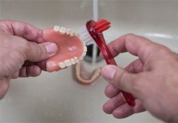 Person cleaning dentures in Goodlettsville