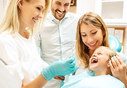A child and her parents at the dental office for family dentistry