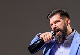 man opening bottle with mouth