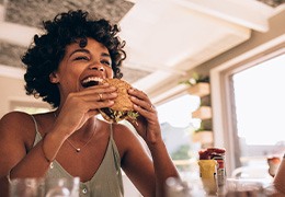 Woman smiling while eating lunch at restaurant