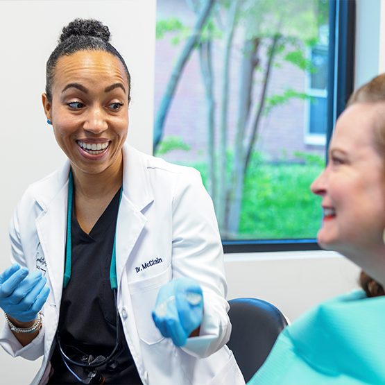 Doctor McClain talking with a patient in the dental chair