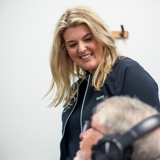 Dental team member smiling at a man in the treatment chair