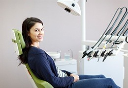 Smiling woman in dental chair for preventive dentistry exam