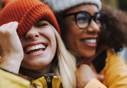 Friends laughing with healthy smiles after dental checkups and teeth cleanings