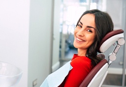 Smiling woman leaning back in dental chair