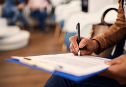 woman filling out dental insurance form in lobby