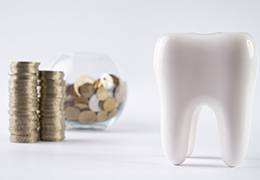 Tooth next to a pile of coins