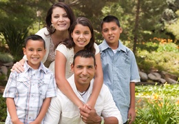 Familia sonriendo juntos mientras está parado afuera