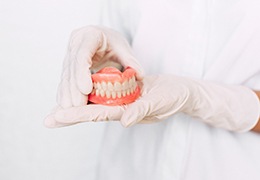 Dentist holding dentures in Goodlettsville