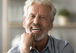 An older, smiling man enjoying his dentures