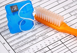 dental insurance form with toothbrush and floss