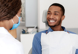 a patient smiling while speaking with their dentist