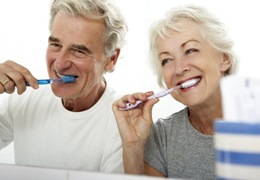 elderly couple brushing their teeth together