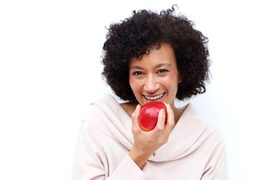 woman biting into a red apple