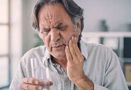An older man having side effects from dental implant placement