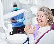 elderly woman giving a thumbs-up in the dental chair