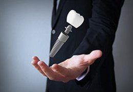 man holding a dental implant in his hand