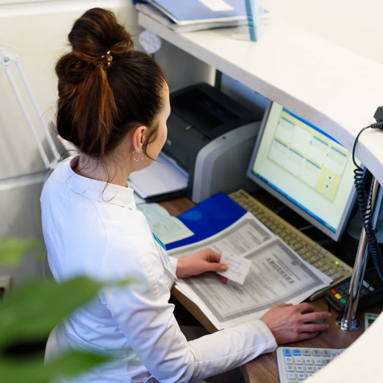 a business woman on a computer sitting at a front desk