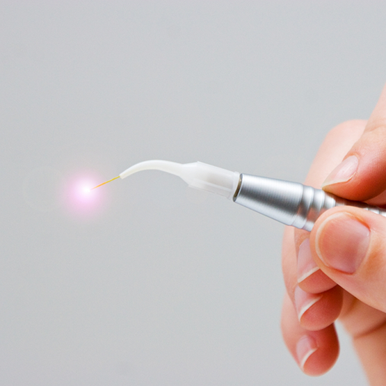 Hand holding a thin metal dental laser