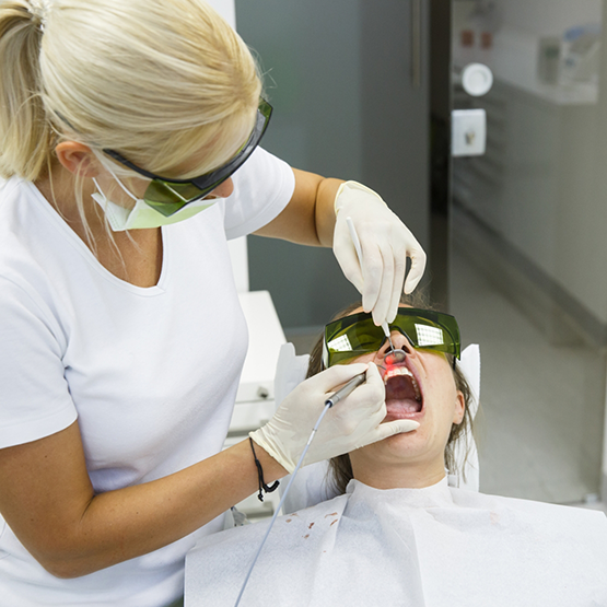 Dentist treating a patient with a laser