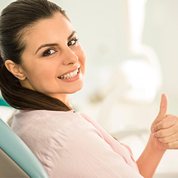 Happy dental patient making thumbs up gesture