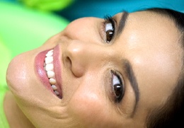 A female patient smiling after porcelain veneer treatment