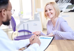 A woman talking with her dentist during a porcelain veneers consultation
