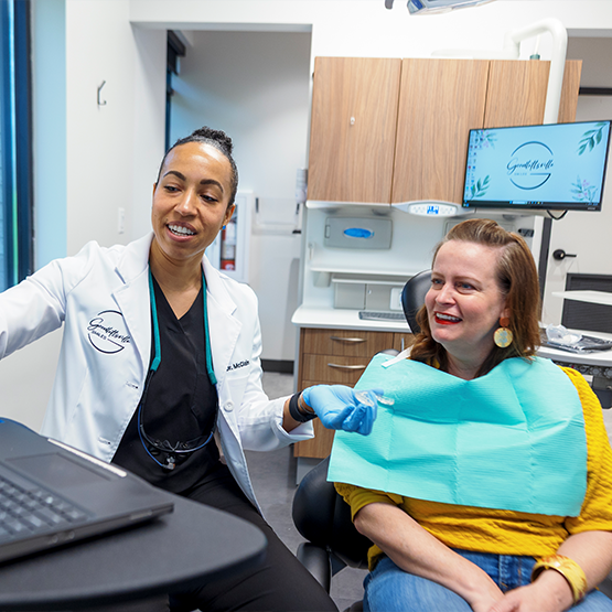 Doctor McClain showing a dental patient something out of frame