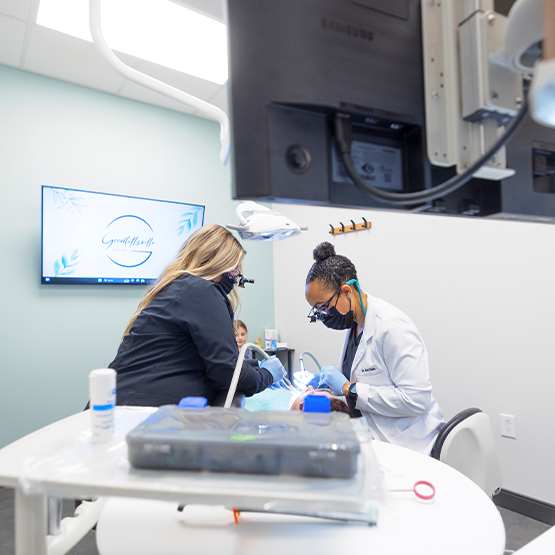 Doctor McClain and a dental assistant performing a procedure on a patient