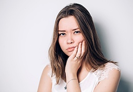 a woman holding her cheek due to severe toothache