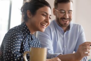 two people smiling and drinking coffee