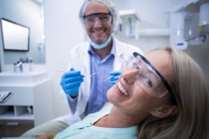 mature woman dental chair smile in mirror 